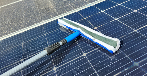 Solar panel cleaning brush being used to clean solar panels efficiently